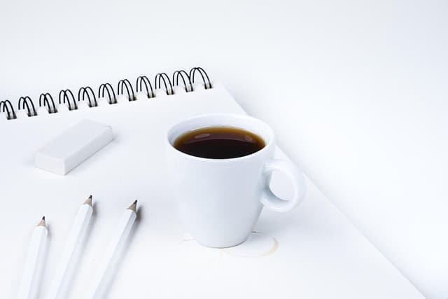 Neutral desk with coffee and stationery